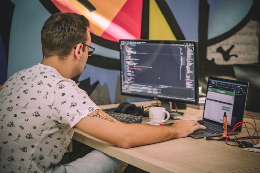 Picture shows developer who are coding at his laptop