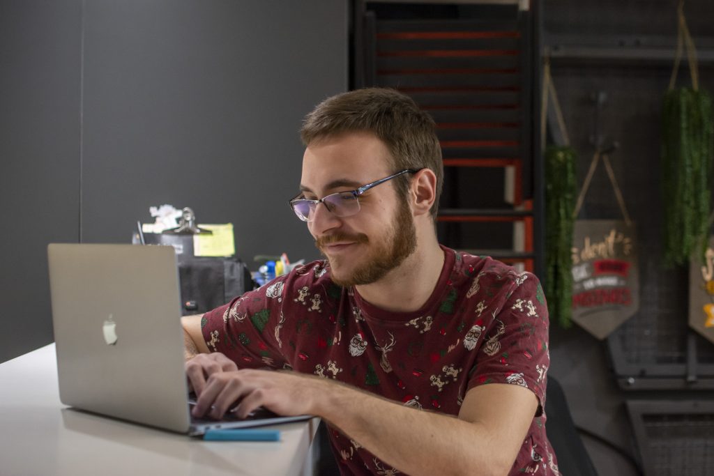 Picture shows man who are sitting at the bar with his laptop and working