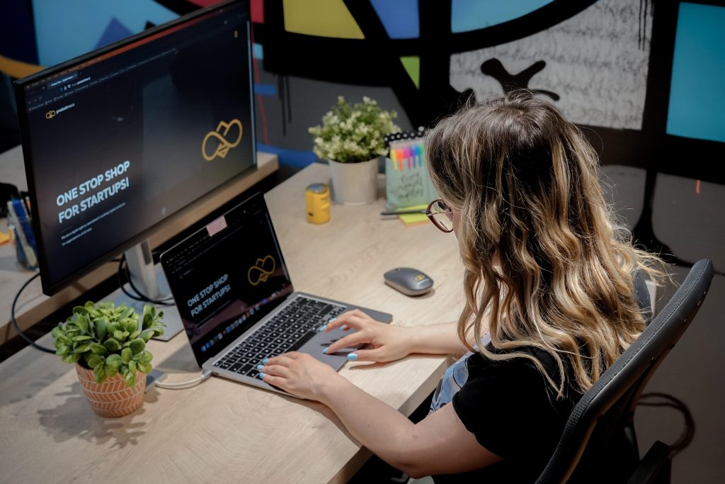 Picture shows girl who are sitting and working on the laptop